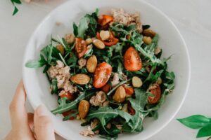 Rucola-Salat mit Tomaten auf weißer Keramikschale